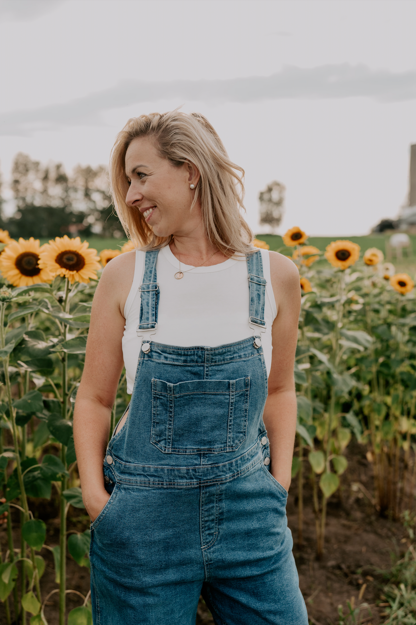 Femme cueillant des pivoines dans un champ en fleurs à la Pivoinerie Lili